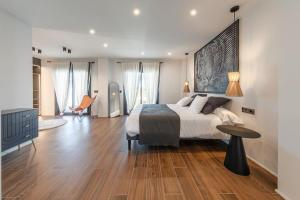 ein Schlafzimmer mit einem großen Bett und Holzböden in der Unterkunft Villa con Piscina Privada in Gelves + 48 Fotos