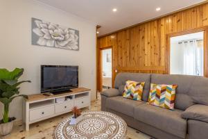 un soggiorno con divano e TV a schermo piatto di La posada de Itálica a Santiponce