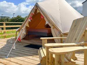 una tenda con due sedie e una panca su un ponte di Greystones Glamping - Tent 2 a Greystones