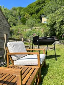 ein paar Stühle und ein Grill im Gras in der Unterkunft Springbank Cottage in Stroud