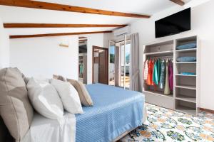 a bedroom with a bed and a tv and a closet at YourHome - Jolly Pini Apartment in Sant'Agnello