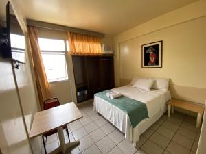 a small bedroom with a bed and a window at Prestige Manaus Hotel in Manaus