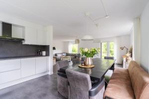 uma cozinha e sala de estar com mesa e cadeiras em Modern Luxury villa em Zeewolde