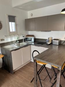 a kitchen with a sink and a wooden table at Bel appartement - 2 chambres- bord de plage- vue mer-climatisé in Bormes-les-Mimosas