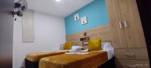 - 2 lits dans une chambre aux murs jaunes et bleus dans l'établissement Apartamento cerca parque del Café con Piscina, à Montenegro