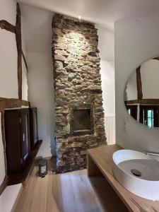 a bathroom with a stone fireplace and a sink at Au vieux nid, circuit de spa Francorchamps in Stavelot +25 photos