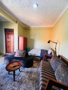 a living room with a couch and a bed at Botique Inn in Kampala