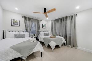 a bedroom with two beds and a ceiling fan at Westchester Garden in Miami