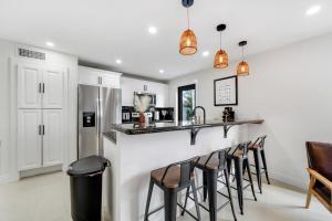 a kitchen with a bar with stools at Westchester Garden in Miami