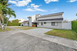 a white house with a driveway and palm trees at Westchester Garden in Miami