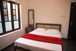 Un dormitorio con una cama con una manta roja. en Shivas Farmhouse, en Sultan Bathery
