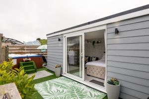 a tiny house with a bedroom on a patio at Adorable private couples retreat with hot tub in Llanfechell