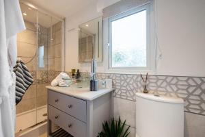 een badkamer met een wastafel, een douche en een toilet bij Adorable private couples retreat with hot tub in Llanfechell