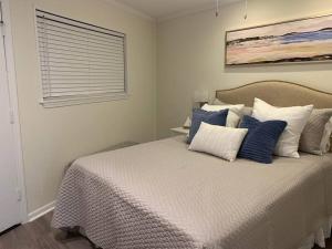 a bedroom with a bed with blue and white pillows at Shore To Please! Elegant couples retreat with bikes in Hilton Head Island +25 photos