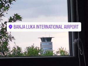 una finestra con un cartello che indica l'aeroporto internazionale di Banana ukka di Fly & Stay Apartments a Laktaši