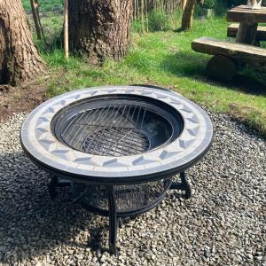 a fire pit in the gravel with a bench at Aughavannagh Yurt Glamping in Aughrim