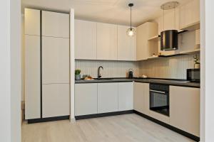 kuchnia z białymi szafkami i zlewem w obiekcie Rin Luxury Apartments Pool & Spa w Bukareszcie