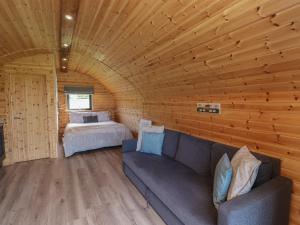 ロッカビーにあるCleugh Lodgeのキャビン内のソファとベッド1台が備わる客室です。