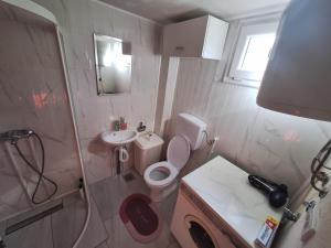 een kleine badkamer met een toilet en een wastafel bij Fly & Stay Apartments in Laktaši