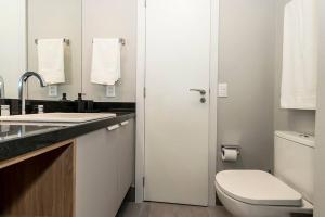 a white bathroom with a toilet and a sink at Loft Moderno novo JPRE718 in Porto Alegre +8 photos