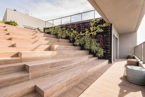 a wall of plants on the stairs of a house at Loft Moderno novo JPRE718 in Porto Alegre