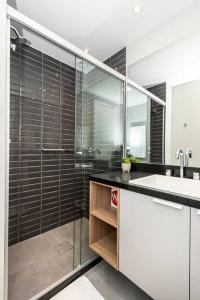 a bathroom with a glass shower and a sink at Loft Moderno novo JPRE718 in Porto Alegre