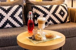 a coffee table with a drink and a plate of food at Complex Vazrozhdentsi in Tryavna