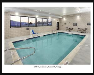 una gran piscina de agua azul en un edificio en Candlewood Suites Detroit Sterling Heights, an IHG Hotel, en Waldenburg