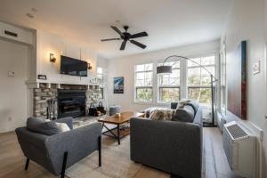 a living room with two couches and a fireplace at Les Eaux 233-2-Alpine Family Escape in Mont-Tremblant
