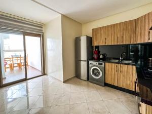 a kitchen with a refrigerator and a washing machine at Appartement de luxe au Parc au centre pres de la plage in Mohammedia