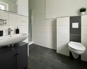 a bathroom with a toilet and a sink at Ferienwohnungen am Park in Wilhelmshaven +18 photos