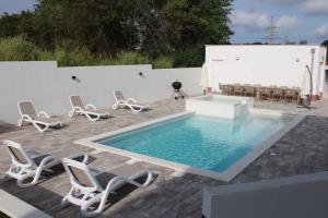 a pool with chairs and a table and a dog at Holiday House emjalemi in Pula
