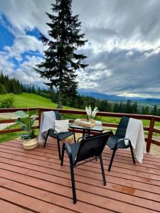 a patio with a table and chairs on a wooden deck at Tatra Glamp Tarasówka in Poronin