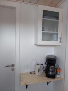 a kitchen counter with a coffee maker on a shelf at Venos rooms 2 in Hirtshals