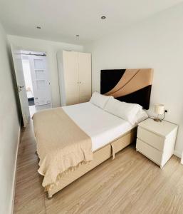 1 dormitorio con 1 cama grande y mesita de noche en Dávila HOME Beach en Santander