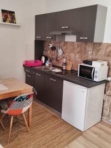 una pequeña cocina con microondas y mesa en Guest House ZoNa, en Pula