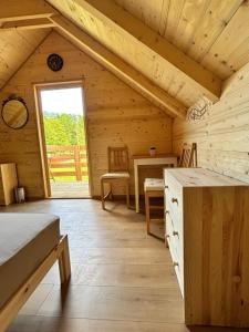 um quarto num chalé de madeira com uma mesa e uma janela em Green River - robinzonski kamp em Duga Resa