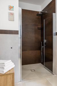 a shower with a glass door in a bathroom at Fiore di Vendicari B&B - Sicilian Charme, Lemon Grove and Sea in Noto