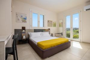 a bedroom with a bed with a yellow blanket on it at Fiore di Vendicari B&B - Sicilian Charme, Lemon Grove and Sea in Noto