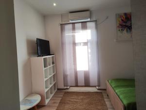 a room with a window and a bed and a television at Guest House ZoNa in Pula