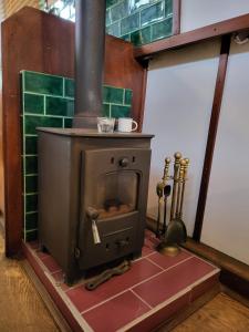 an old wood stove in a room with green tiles at Unique Canal Boat in London Centre for Family & Friends in London