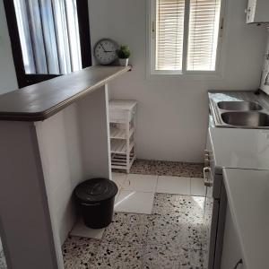 a small kitchen with a counter and a trash can at Duplex en centro de Chipiona in Chipiona