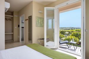 ein Schlafzimmer mit einem Bett und einem Balkon in der Unterkunft Fiore di Vendicari - Near the beaches of Calamosche and Vendicari in Noto