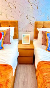 two beds sitting next to each other in a room at Luxe Smart Home - Basildon Serviced Accommodation - 7 Mins Walk To Basildon Town Centre, Hospital & Train Station in Basildon