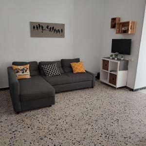 a living room with a couch and a tv at Duplex en centro de Chipiona in Chipiona