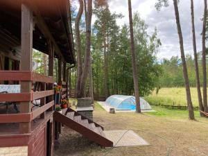 a house with a tent in a field with trees at Wooden House&Pool in Osowa