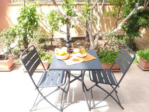 a blue table with two chairs and a plate of fruit at Luna Chiara Residence in Tusa