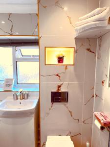 a bathroom with a sink and a toilet at Luxe Smart Home - Basildon Serviced Accommodation - 7 Mins Walk To Basildon Town Centre, Hospital & Train Station in Basildon