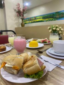 a table with a plate of food with a sandwich at Prestige Manaus Hotel in Manaus
