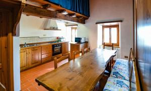 a kitchen with a wooden table and a kitchen with a tableablish at Agriturismo Sperandini in San Marcello Pistoiese